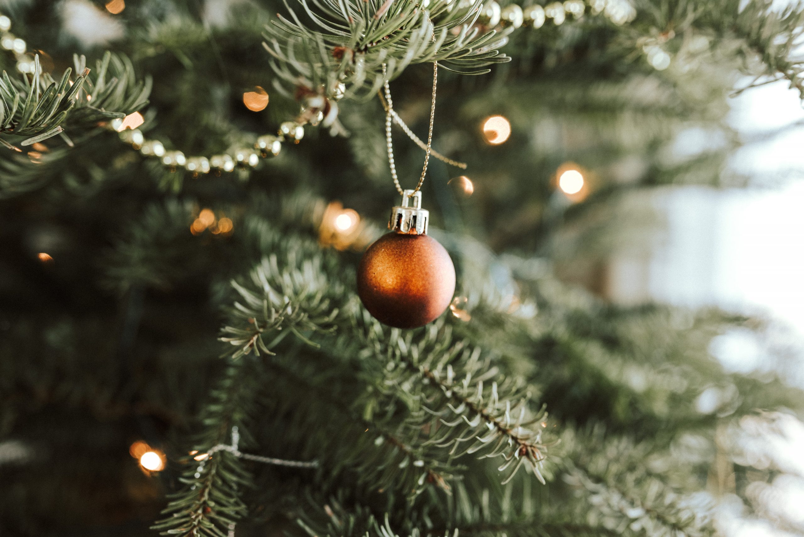 Christmas tree close up with lights and orange bauble